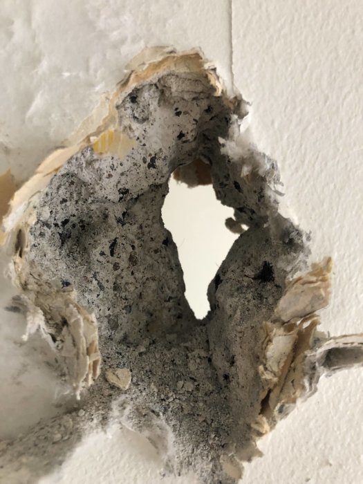 Provborrat hål i en porös vägg som förberedelse för installation av ett gammalt fönster.