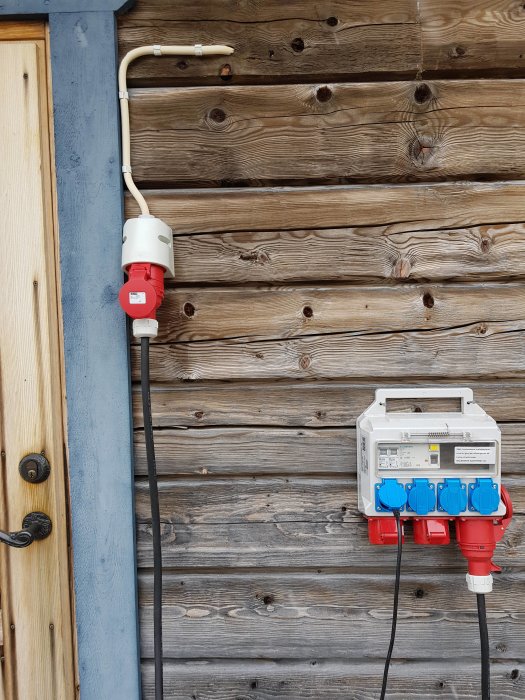 Elcentral med flera uttag och säkerhetsbrytare på en vägg av trä, med förberedningar för byggprojektet.