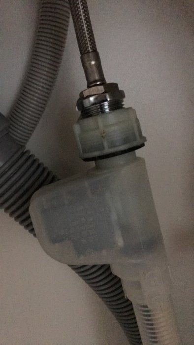 Anslutning mellan diskmaskinslang och blandare med synlig droppbildning.