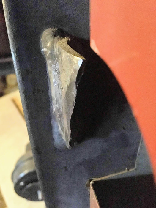 Sliten metallbit som används för att hålla en panndörr stängd, med slitage synligt.