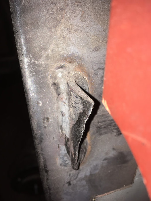 Slitet järnfäste på en panndörr som behöver underhåll eller reparation.