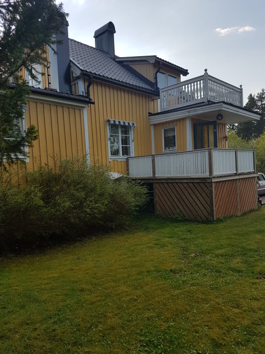 Hus med gul fasad och balkong där användare planerar att bygga ut för två våningar.