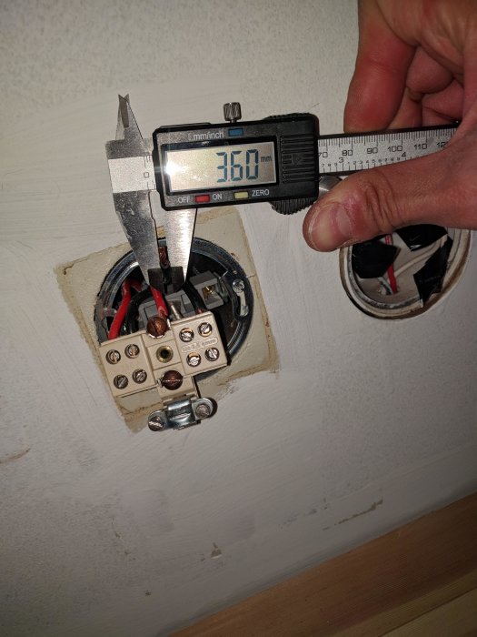 Skjutmått mäter diameter på elkabel vid en vägganslutning, visar 3.60 mm med isolering.