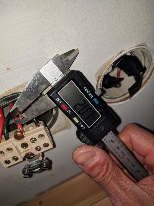 Digital skjutmått mäter diameter på en elektrisk ledare utan isolering vid installation.