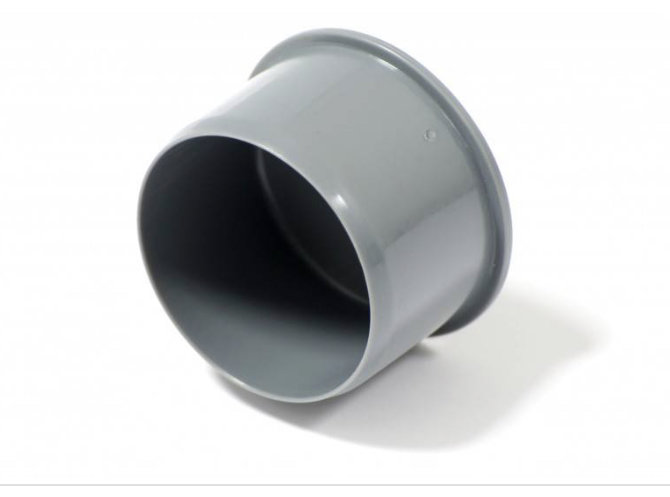 Grå PVC-koppling liggandes på vit bakgrund, troligt byggmaterial för rörinstallation.