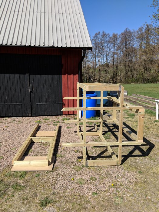 En träkonstruktion under byggnation, bestående av en plattform med stege utomhus.