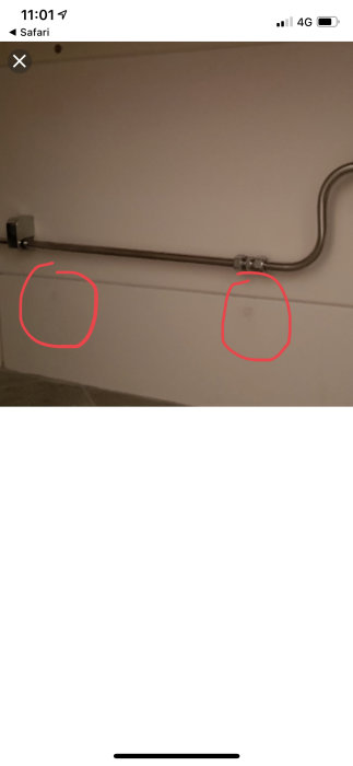 Rörgenomföring i vit kaklad vägg. Rör fästes med klammer och eventuellt silikonförseglade hål är markerade.