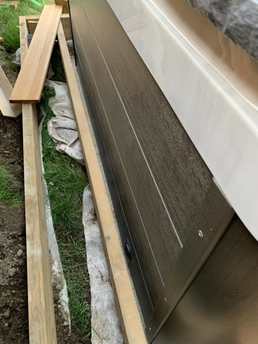 Del av installationen av ett spabad med synlig betongplatta och tralldäck på en veranda under uppbyggnad.