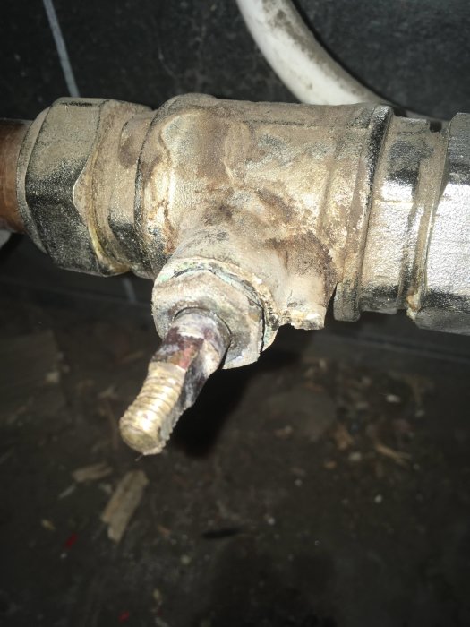 Rörkoppling med handvred täckt av kalkavlagringar, indikerar vattenavstängning eller reparation.