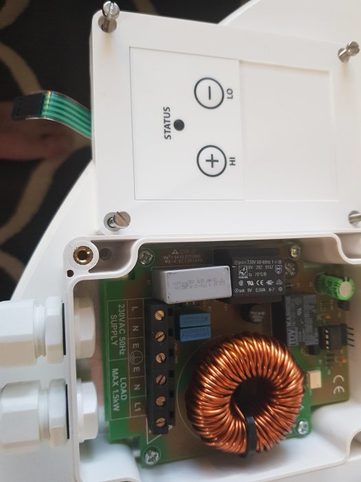 Öppen halogenvärmaredimmer med synliga kablar, kopplingsschema och elektronikkomponenter.