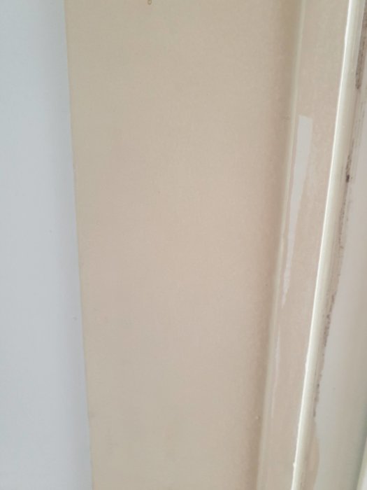 Gamla, ojämnt målade dörrlister i en lägenhet, behöver renovering.