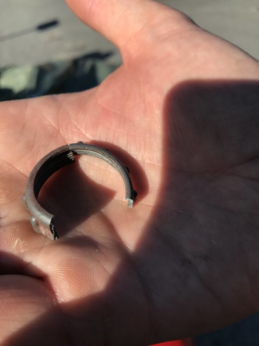 Hand som håller ett skadat, segmenterat trottellock på 30mm i diameter.
