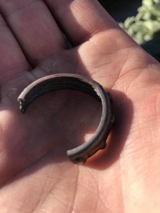 Hand håller ett skadat trottellock på 30mm för en Loncin 125cc motorcykel.
