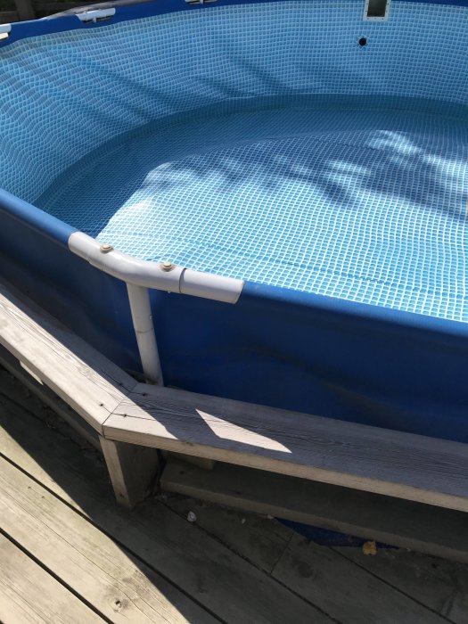 Upplyft poolkantring och en upplyftning av bottenduk på en ovanjordspool som indikerar vattennivåproblem.