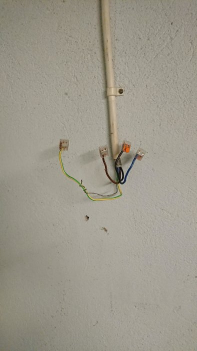 Okopplade elledningar och kopplingsdosor på vägg, möjliga rester av 3-fas anslutning i ett garage.