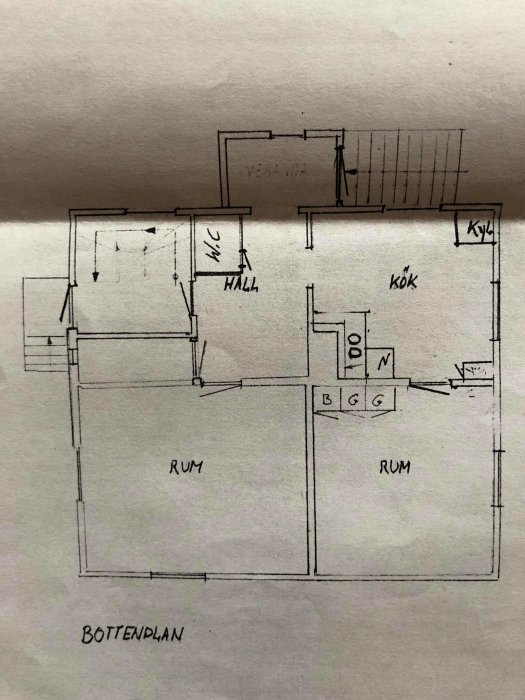 Handritad planritning av bottenplanet i ett hus med markerade rum såsom kök, hall och WC.