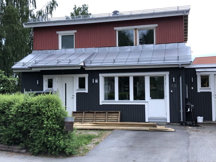 Ett nyinstallerat snörasskydd på framdelen av ett hus med röd panel och borttagen byggställning.