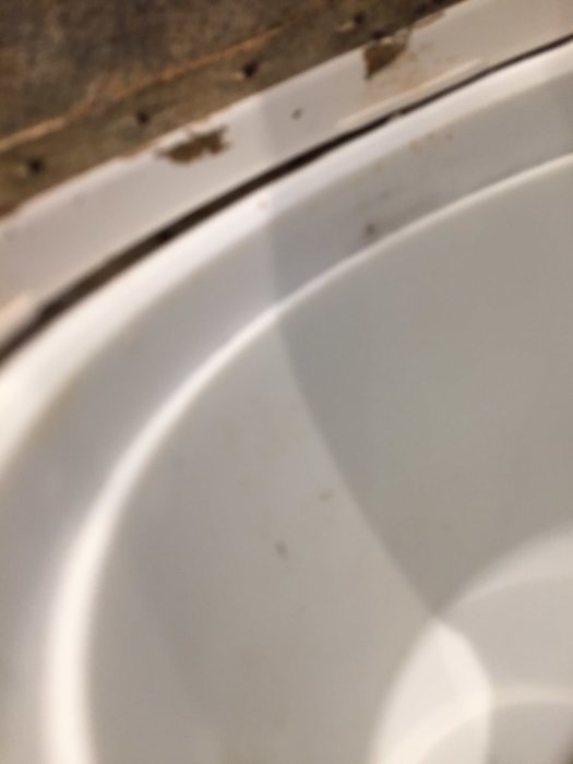 Närbild på en golvbrunn i ett badrum med synliga skarvar och lätt smuts, fråga om korrekt installation.