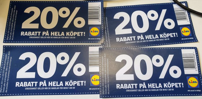 Fyra rabattkuponger på 20% för en byggmarknad, utlagda på ett bord.