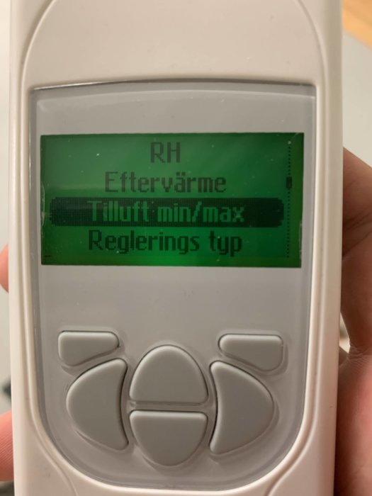 Handhållen enhet med display som visar menyalternativ inklusive 'Eftervärme' och 'Tilluft min/max'.