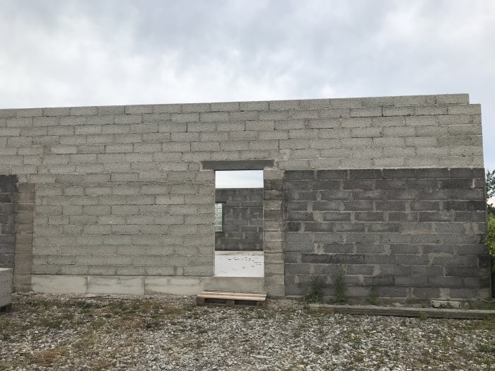 Nybyggd främre vägg på 3,4 meter av betongblock med öppning för garageport.