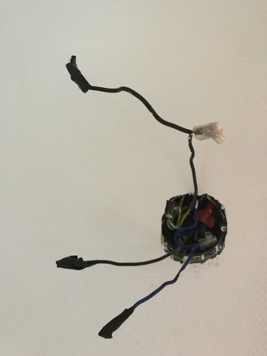 Eluttag med lösa kablar och en varvtalsregulator för badrumsfläkt uttagen ur väggen.