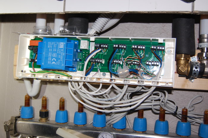 Öppen kopplingsbox för LK golvvärmeinstallation med termostater, ställdon och kablage synligt.