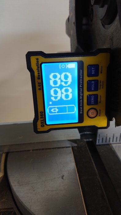 Digitalt vinkelverktyg med en display som visar 88, 98 grader på en arbetsbänk.