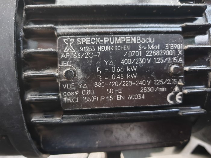 Närhetsbild på en poolpumpens typskylt som visar tekniska specifikationer inklusive effekt och spänning.