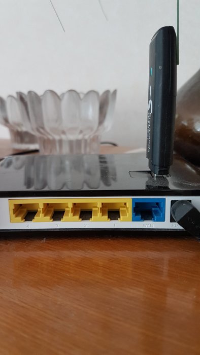 En router med ansluten USB-dongel och synliga LAN-portar märkta med siffror.