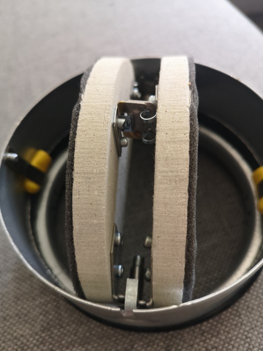 Brandspjäll i öppet tillstånd med synlig mekanism, inklusive gula detaljer, avsett för montage i ventilationsrör.