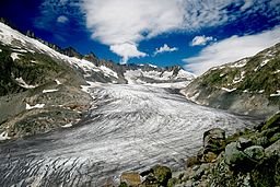 Vy över en glaciär omgiven av berg och stenar, representerar betydelsen av smältvatten från glaciärer.