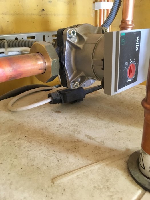 Innedel av värmesystem med kablar och kopparledning ansluten till styrenhet.