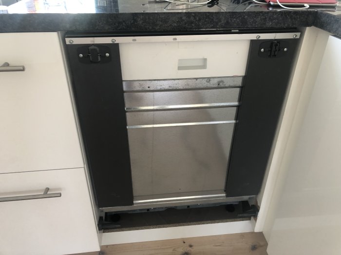 Äldre Ikea Lagan diskmaskin med öppen lucka visandes trasig plastglidhållare och en monterad skena i mitten.