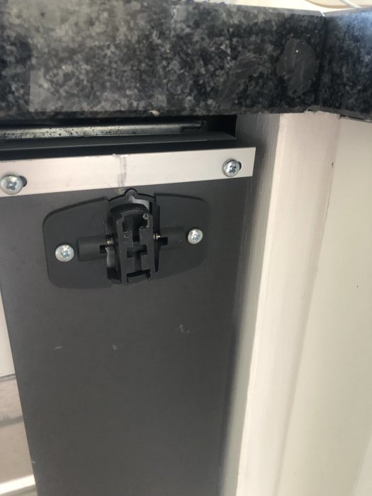 Söndrad glidhållare i plast på en Ikea Lagan diskmaskin, luckan hänger löst.