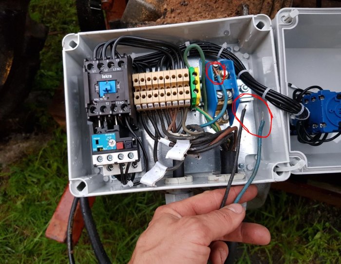 Elkablar och komponenter inne i en öppen elektrisk kopplingslåda med synliga lösa kablar och plintar.