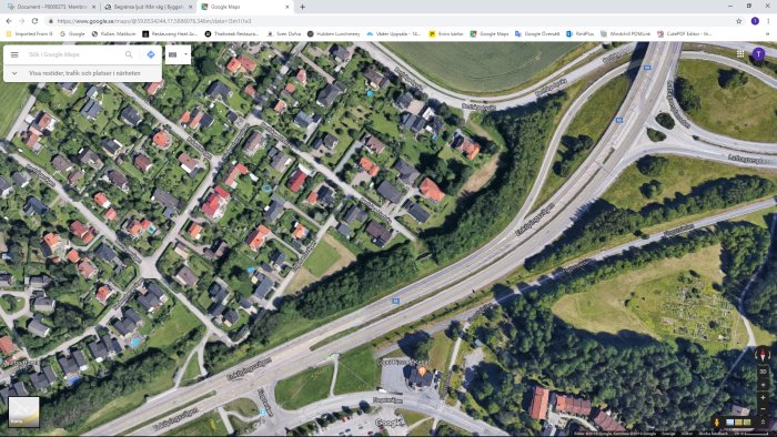 Satellitbild från Google Maps som visar en bostadsområde brevid en motorväg och rondell.