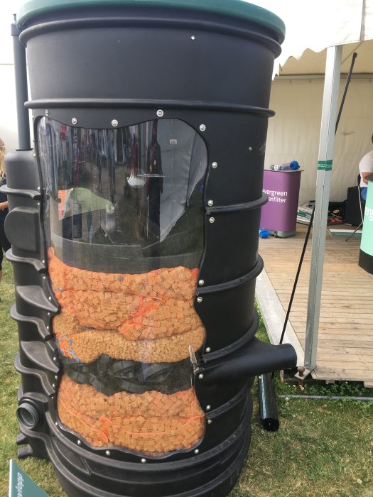 En kompostbehållare från 4evergreen visas på mässan, fylld med kork och synlig innehållsstruktur.