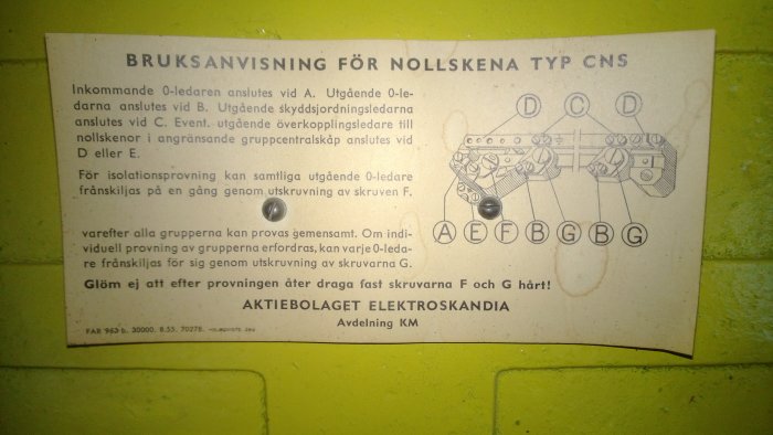 Gammal bruksanvisning för nollskena med text och skiss, monterad på en grön vägg.
