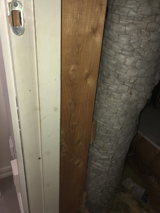 Omfluten ventilationskanal nära en dörröppning och en träregel, i ett ombyggt köksprojekt.