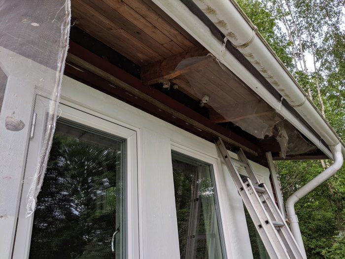 Renoverat takfot med synliga träbjälkar och rör där plyfan har tagits bort.