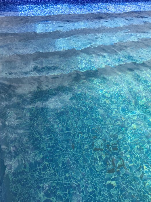 Bilden visar poolvatten med klarblå linjer längst upp och en grönaktig ton i den djupare delen.