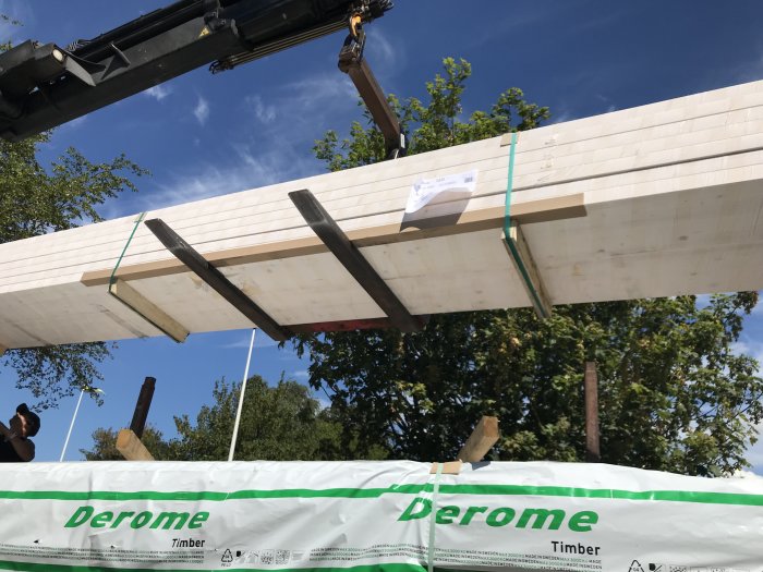 Nyinstallerad balk för garageport och hammarband i trä under byggnation av takkonstruktion.