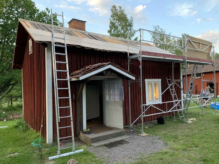 Renovering av rödfärgat hus med delvis pålagd takisolering, ströläkt och säkerhetsställning.