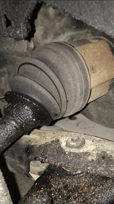 Bilens drivaxel med gamla damasken delvis borttagen nära växellådan.