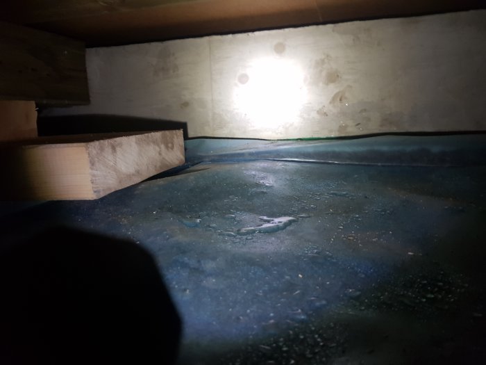 Delvis fuktig plastfolie i utrymme med synliga vattendroppar och torra områden.