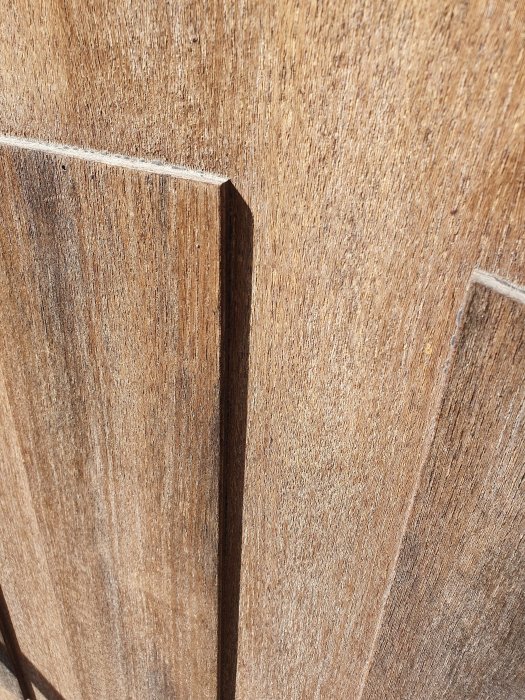 Närbild på en sliten ytterdörr av oidentifierat träslag från Leksandsdörren som behöver renovering.