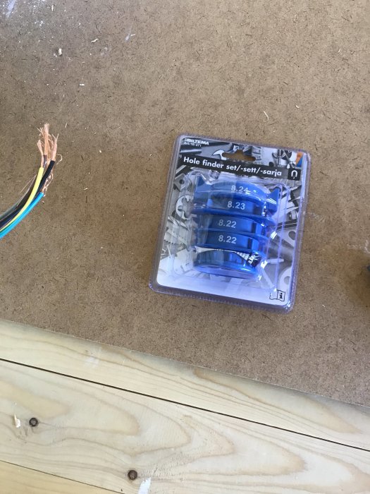 Hole finder kit bredvid elektriska kablar på en oskyddad trävägg under renovering.