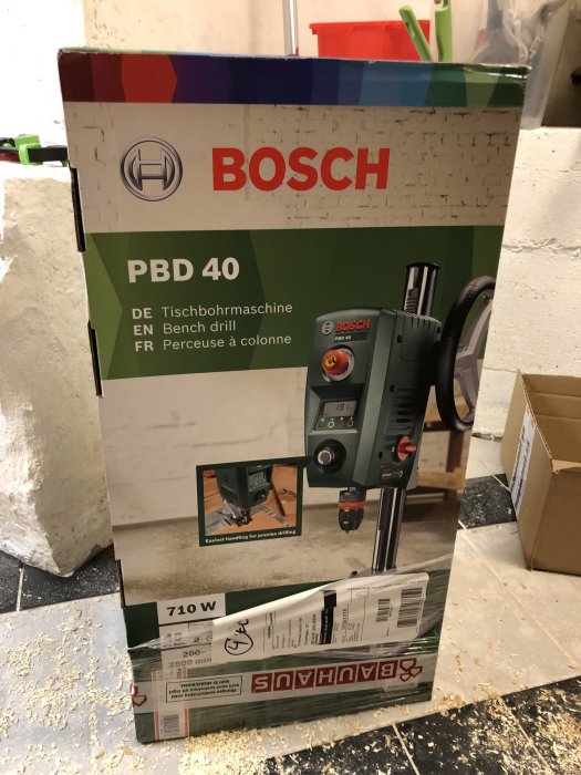 Bosch PBD 40 bänkborrmaskins förpackning från Bauhaus på ett verkstadsgolv.