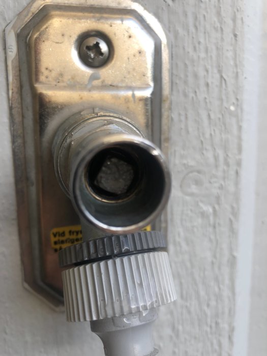 Intryckt fyrkantsstav i mitten av en utomhuskran märkt med VA, troligen från Vårgårda Armatur.